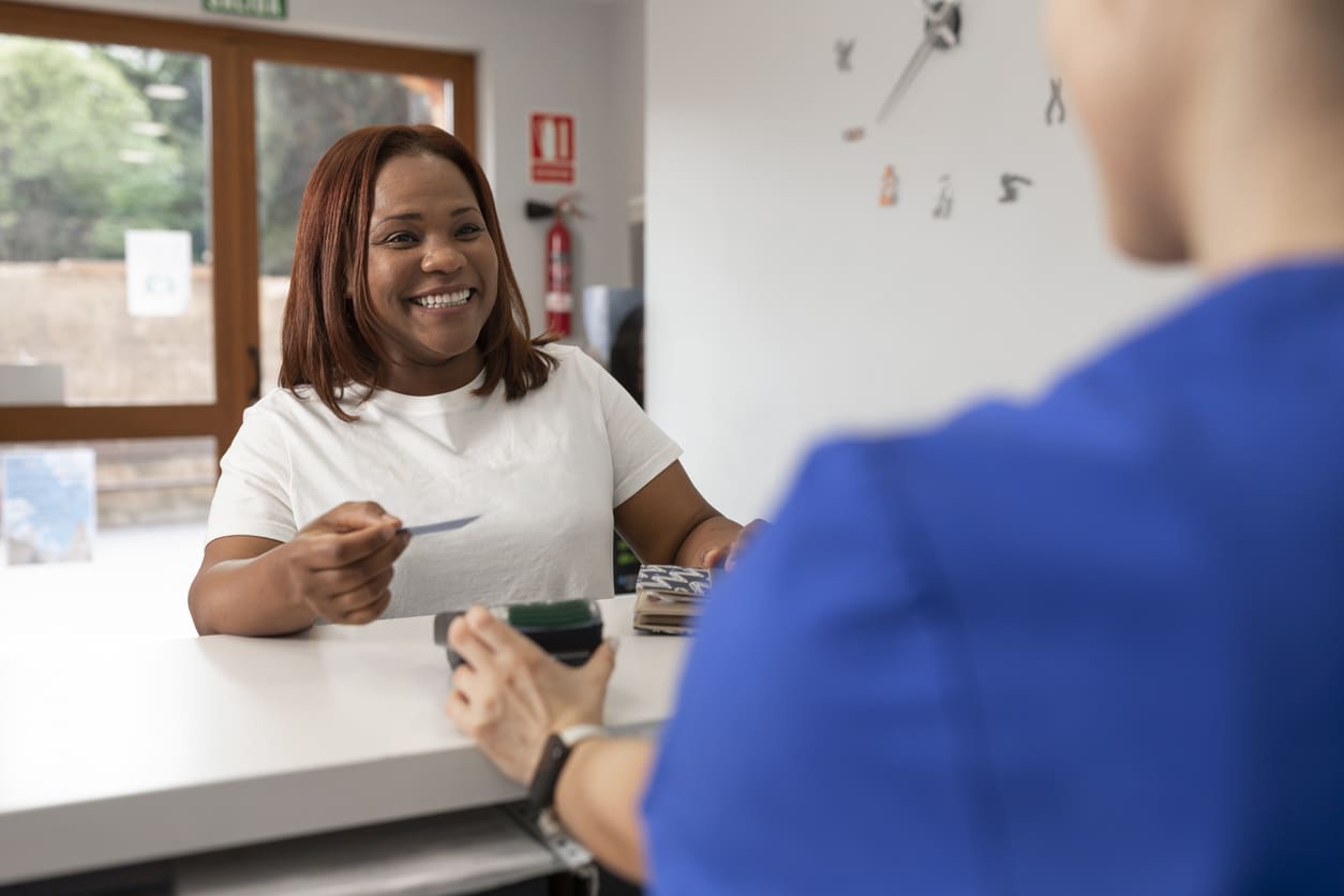 A smiling woman holds her banking card while enjoying the convenience of community banking in Nashville.
