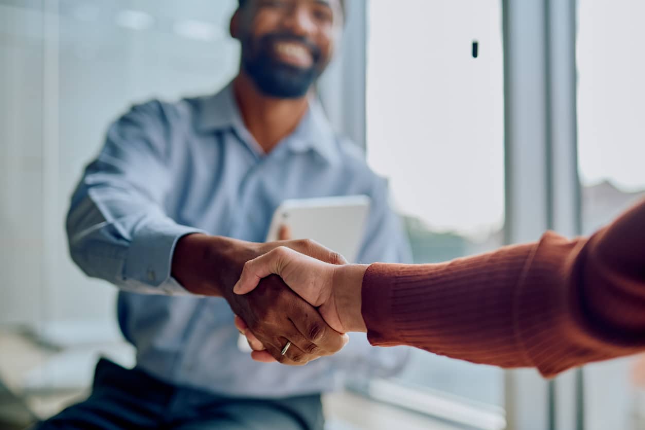 Two individuals shaking hands as community bank builds customer loyalty through great service.